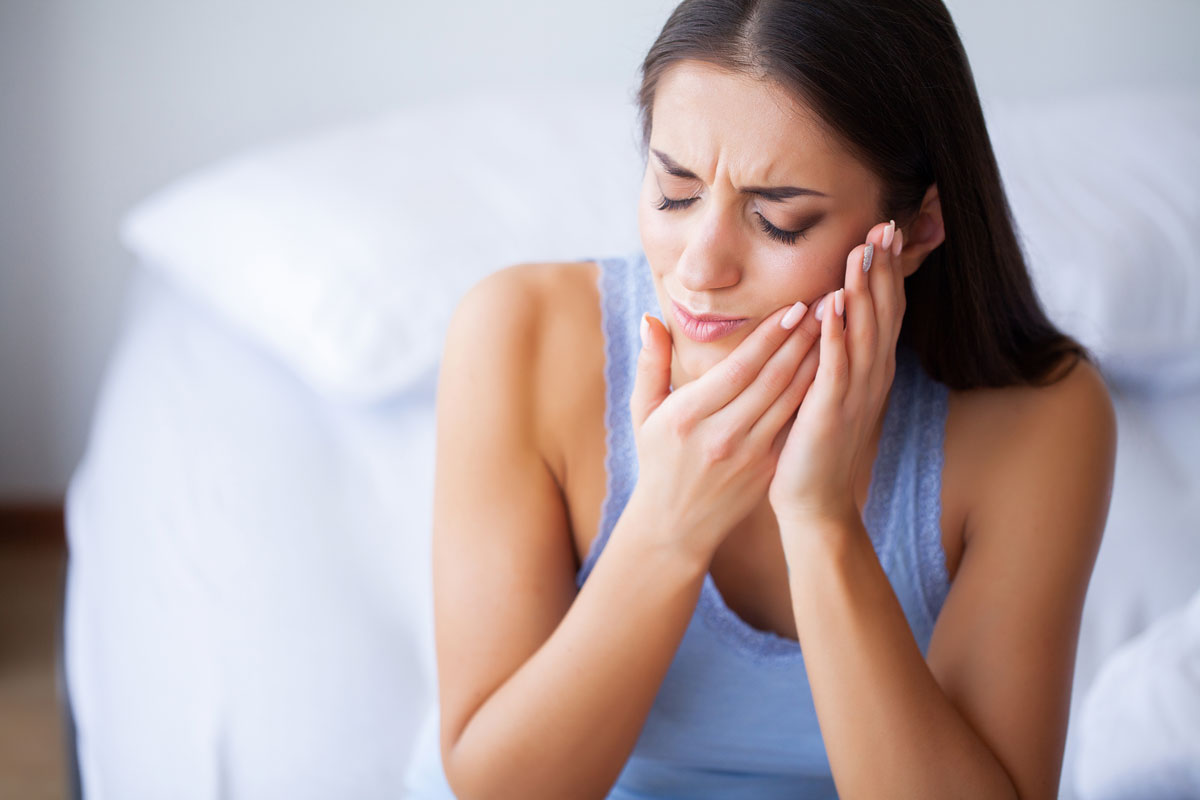 Mujer con dolor de mandíbula por bruxismo